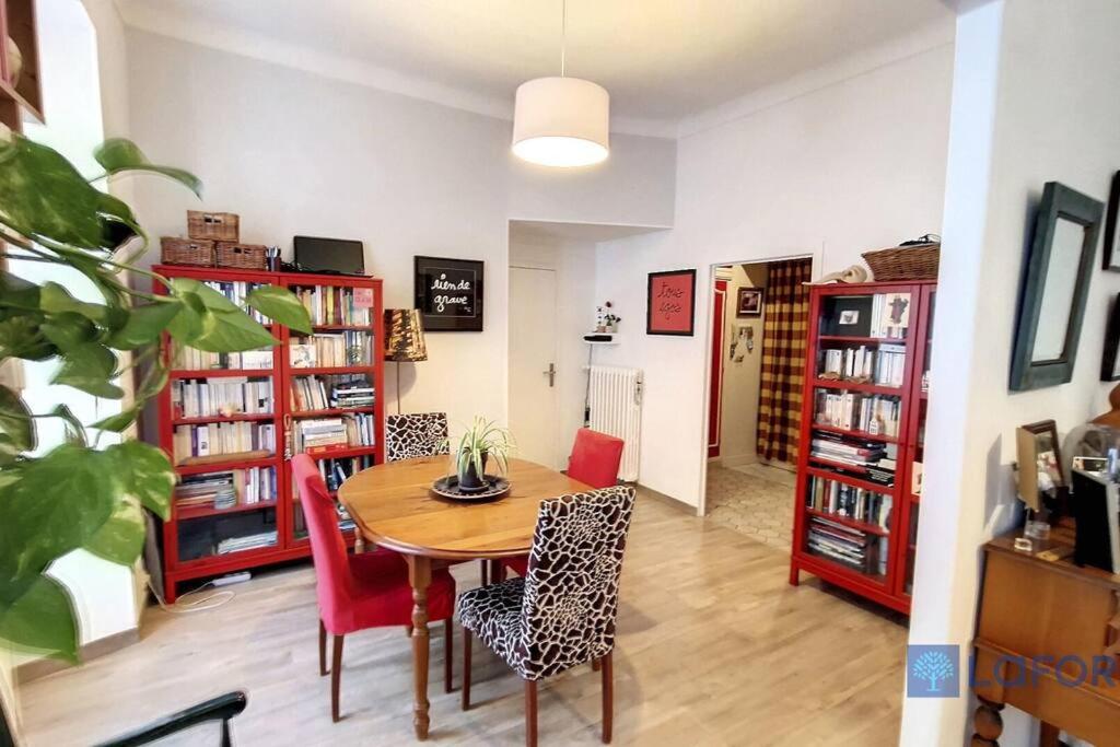 une salle à manger avec une table, des chaises et des étagères dans l'établissement 2P central de Nice avec balcon, à Nice