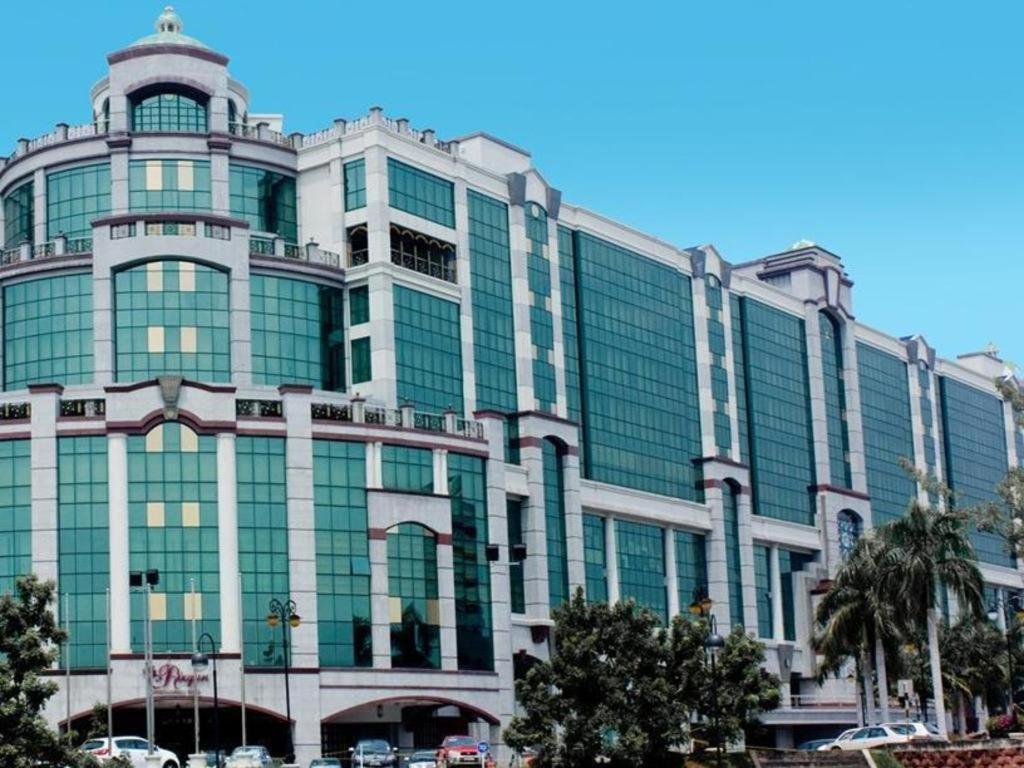 The Rizqun International Hotel في Kampong Gadong: مبنى زجاجي كبير فيه سيارات تقف امامه