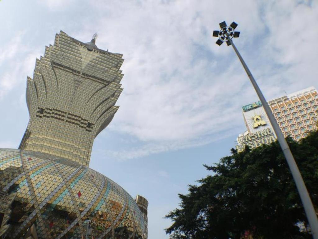 ein Straßenlicht mit einer Statue eines Gebäudes in der Unterkunft Grand Lisboa Hotel in Macau