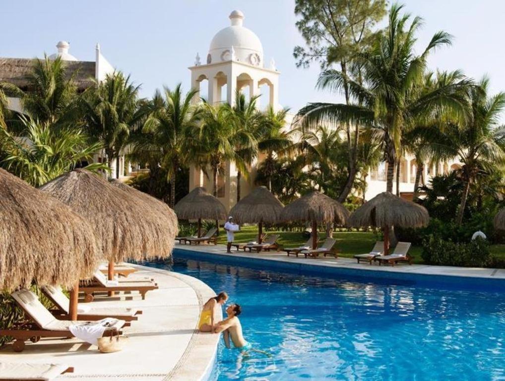 a pool at a resort with people in the water at Excellence Riviera Cancun All Inclusive - Adults Only in Puerto Morelos