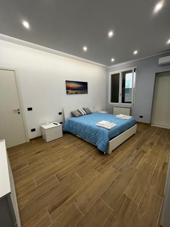 1 dormitorio con 1 cama y suelo de madera en PARADISO HOME, en Augusta