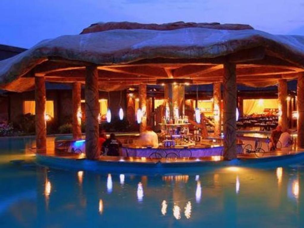 un resort con bar in acqua di notte di Chrismar Hotel a Riverside