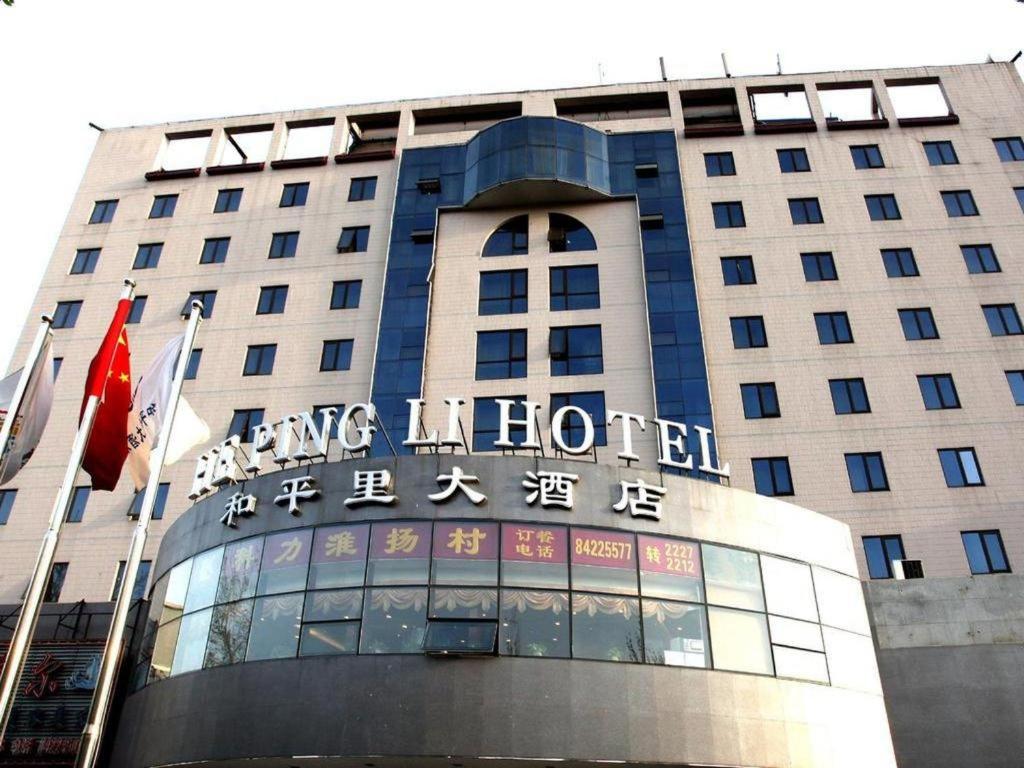 Un bâtiment avec un panneau en haut dans l'établissement Beijing Hepingli Hotel, à Pékin