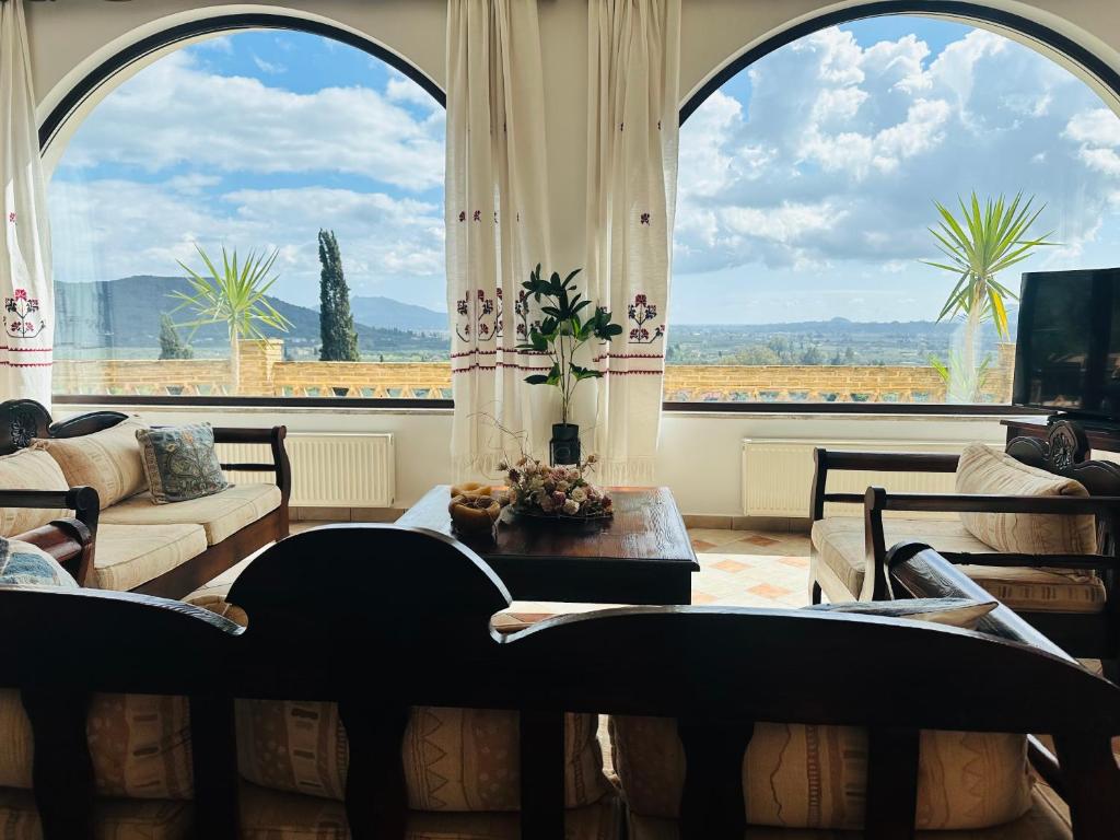 uma sala de estar com uma grande janela e um sofá em Villas Lugrezia Sea View em Méson Yerakaríon