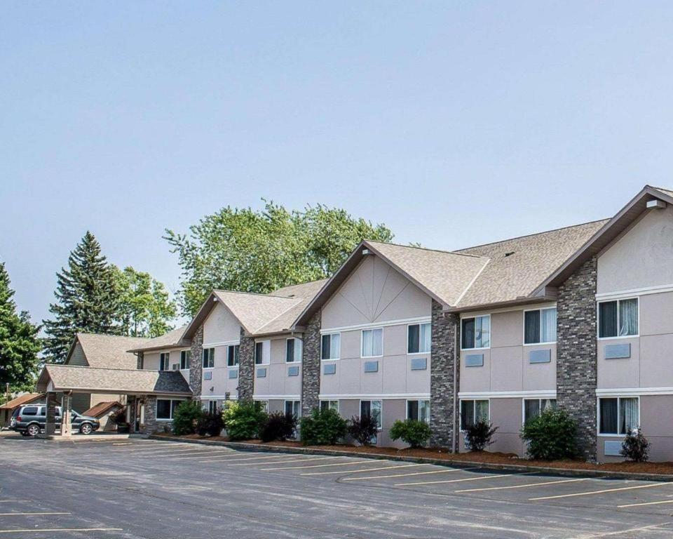 a large apartment building with a parking lot at Quality Inn & Suites in Sturgeon Bay