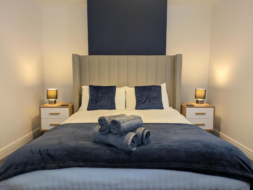 um quarto com uma cama grande e toalhas em Blue Horizon Holiday Cottage - 4 Minute Walk to the Beach em Weymouth