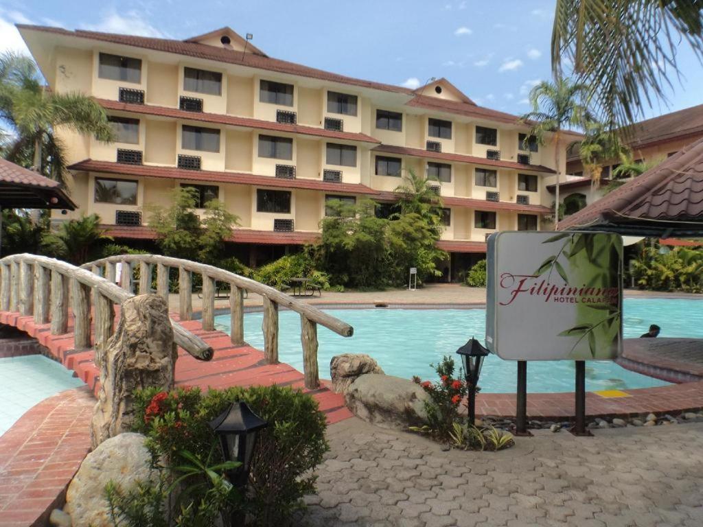un hotel con un cartel frente a una piscina en Filipiniana Hotel Calapan, en Calapan