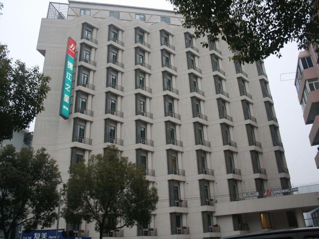 un edificio blanco alto con un letrero. en Magnotel Business Shanghai New International Exhibition Center en Shanghái