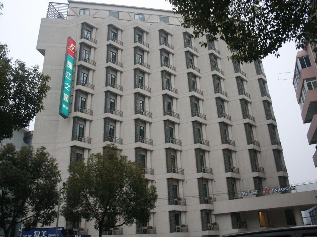 a tall white building with a sign on it at Magnotel Business Shanghai New International Exhibition Center in Shanghai