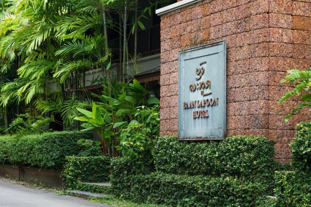 a sign on the side of a brick building at Baan Lapoon Hotel in Lamphun