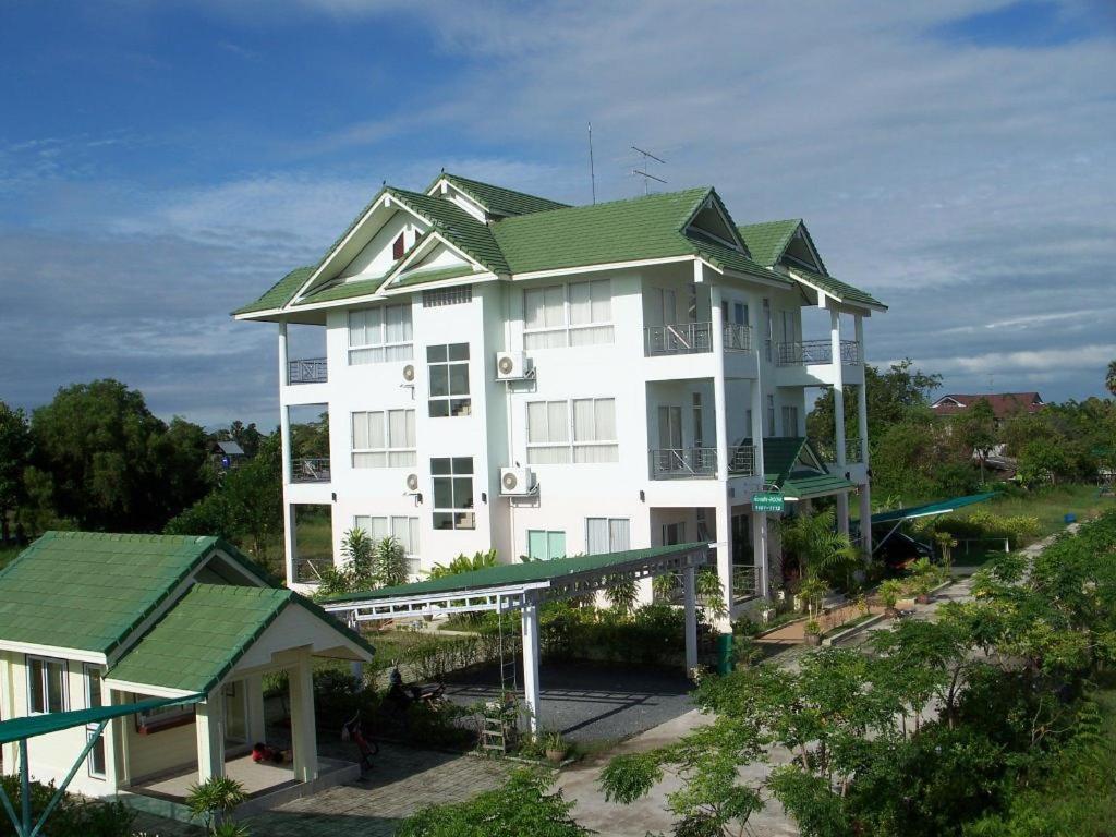 un grand bâtiment blanc avec un toit vert dans l'établissement Kasem Garden Hotel Surin, à Ban Nong Tao