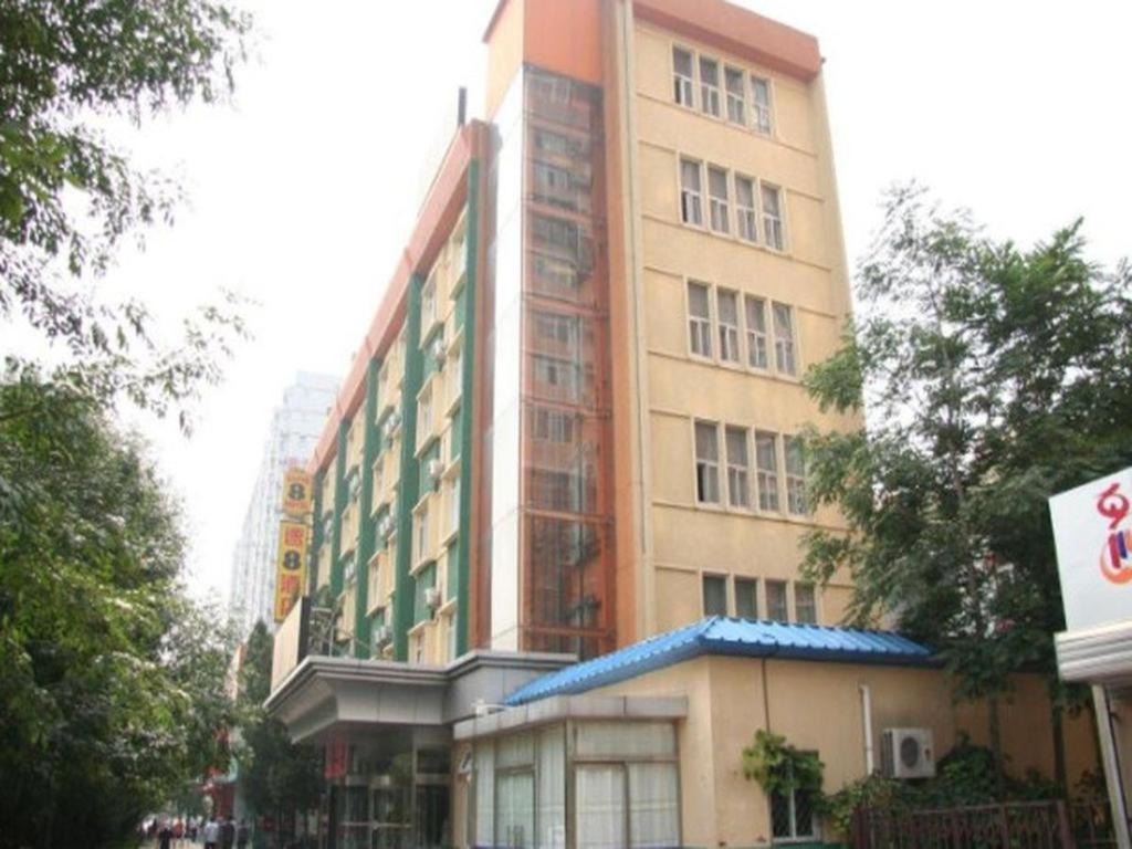 un edificio alto al lado de una calle en Super 8 Hotel Beijing International Exhibition Center, en Beijing