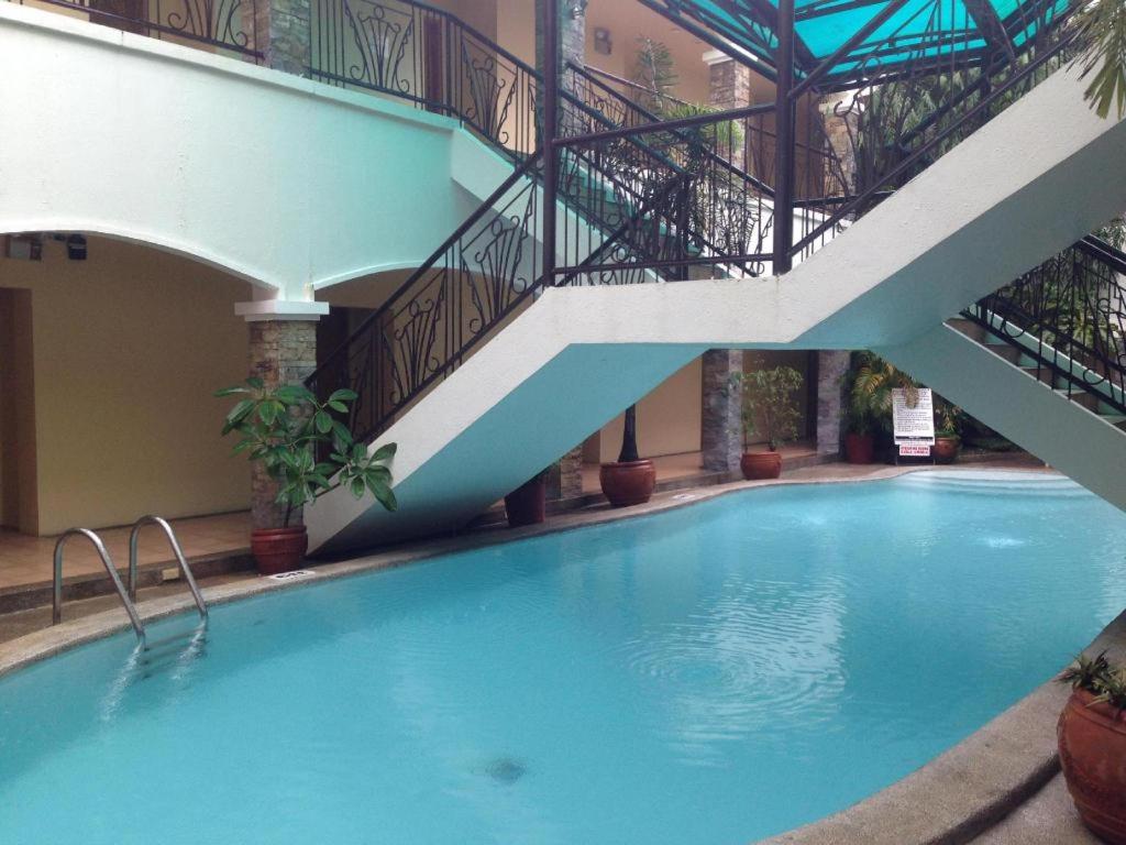 een groot zwembad met een trap in een gebouw bij Bayfront Hotel Subic in Olongapo