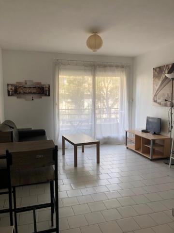 ein Wohnzimmer mit einem Tisch und einem Fenster in der Unterkunft Studio tout confort La Timone in Marseille