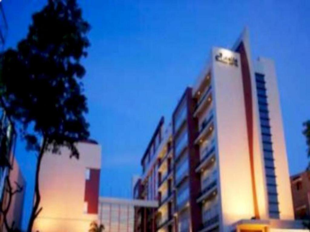 Lampung的住宿－Amalia Hotel Lampung，一座高大的建筑,旁边有一个标志