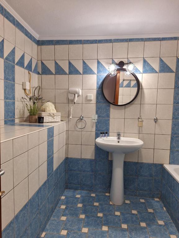 a bathroom with a sink and a mirror at Studio Eleni in Néa Agathoúpolis