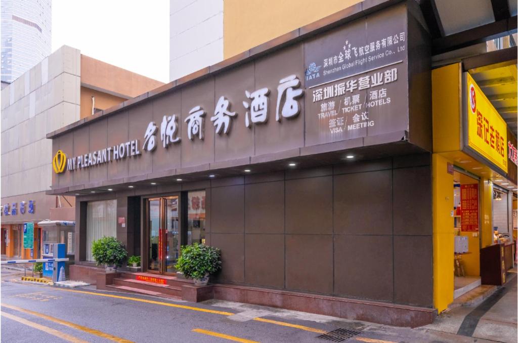 a building with a sign on the side of a street at My Pleasant Hotel in Shenzhen
