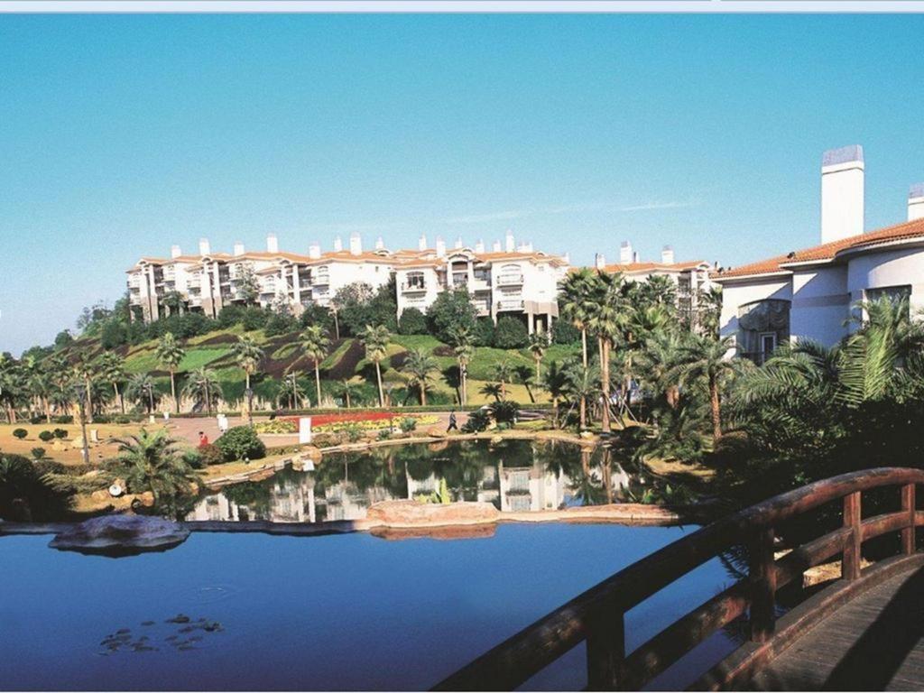 XingshaにあるChangsha ST-Tropez Hotelの池と建物のあるリゾートの景色を望めます。