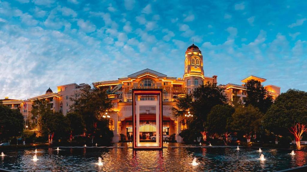 un bâtiment avec une tour d'horloge au sommet dans l'établissement Country Garden Phoenix Hotel Xianning, à Wenquanzhen