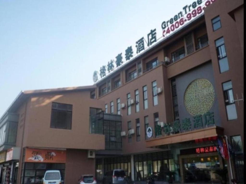 un grand bâtiment avec un panneau en haut dans l'établissement GreenTree Inn Jiangsu Wuxi Meiyuan Kaiyuan Temple Subway Master Station Express Hotel, à Xuedian