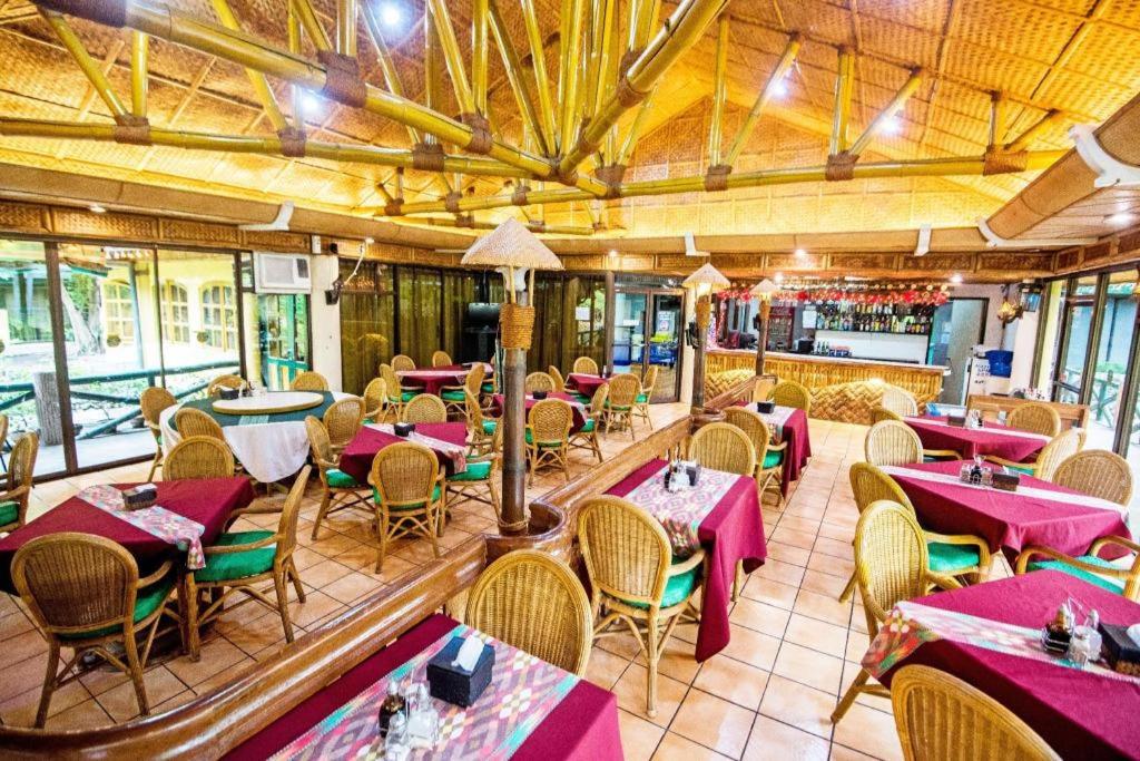 ein Restaurant mit Tischen und Stühlen und eine Bar in der Unterkunft Family Country Hotel and Convention Centre in Lagao