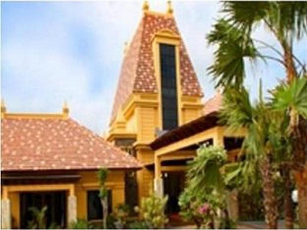 a yellow house with a steeple and palm trees at The Star Hill Boutique Hotel in Stalkudo
