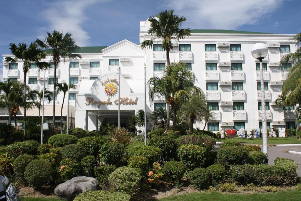 un hotel con palmeras frente a un edificio en East Asia Royale Hotel en Lagao
