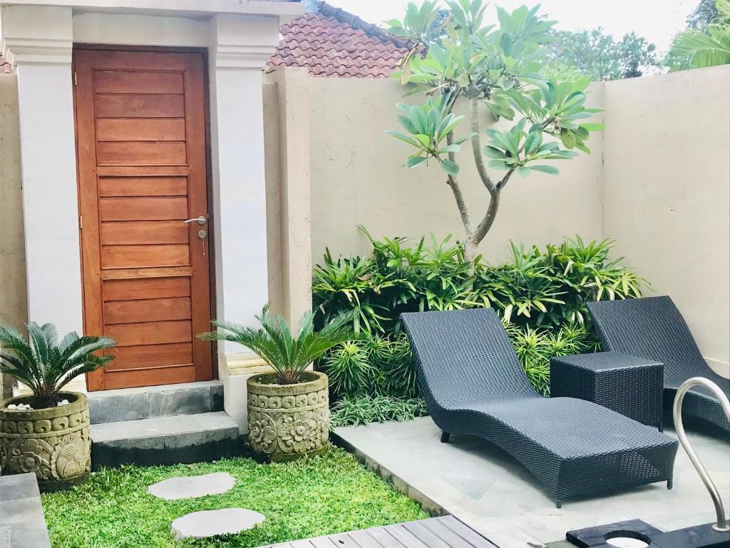 una casa con due sedie e una porta in legno di Londo Villa at Londo House ad Ubud