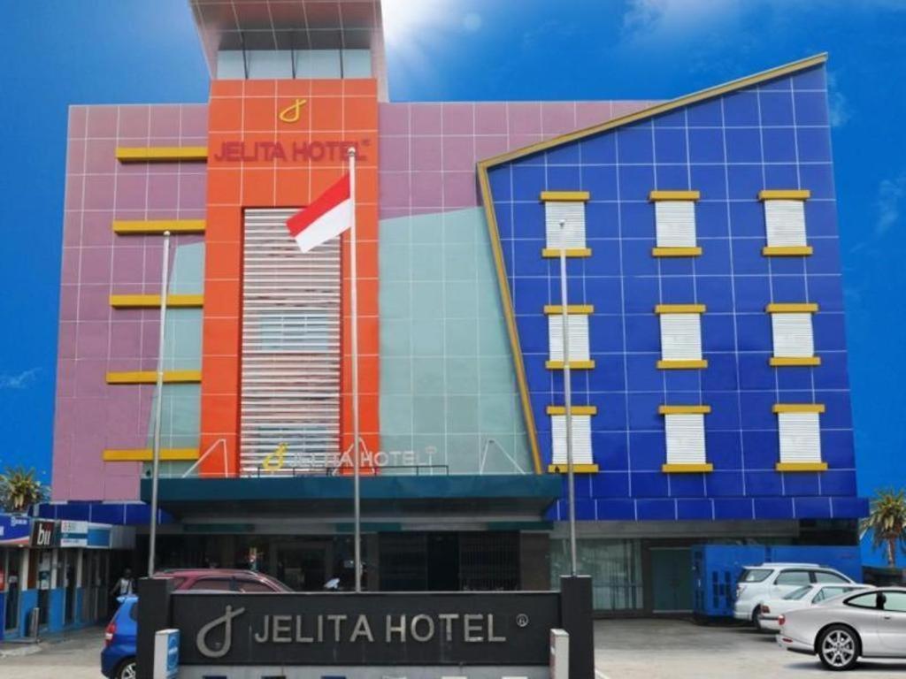 Cet hôtel occupe un bâtiment coloré doté d'un drapeau rouge. dans l'établissement Jelita Hotel, à Banjarmasin