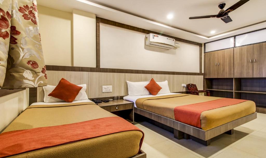 a hotel room with two beds in a room at Hotel Neem Tree Hyderabad Airport in Shamshabad