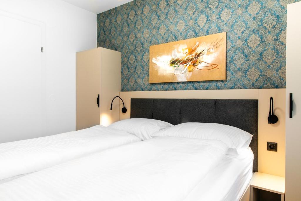 Un dormitorio con una cama blanca y una pintura en la pared en MyApartments Vienna Rooftop, en Viena