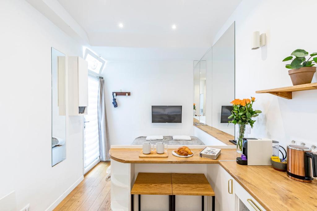 - une cuisine avec des murs blancs et un comptoir en bois dans l'établissement PARIS 3° CENTRE MARAIS -COCON CALME (PROPRETÉ +++), à Paris