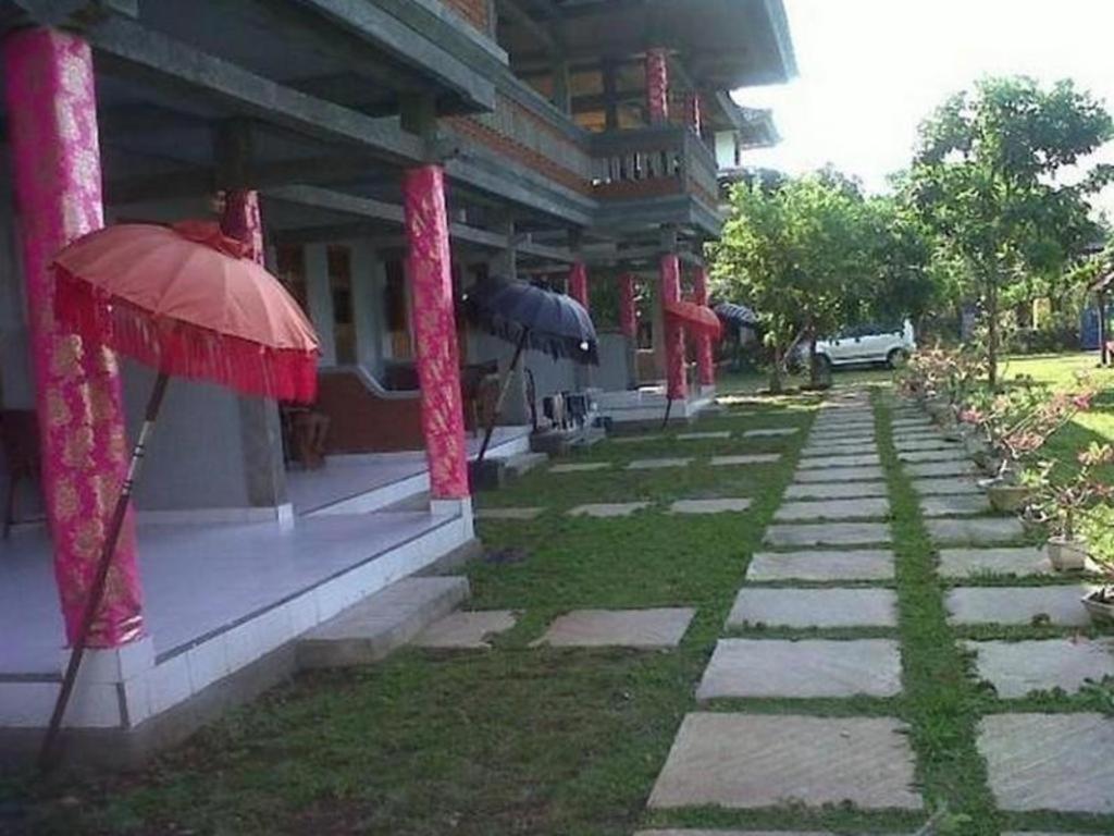 a building with red umbrellas in front of it at Bali Bagus Hotel in Lovina