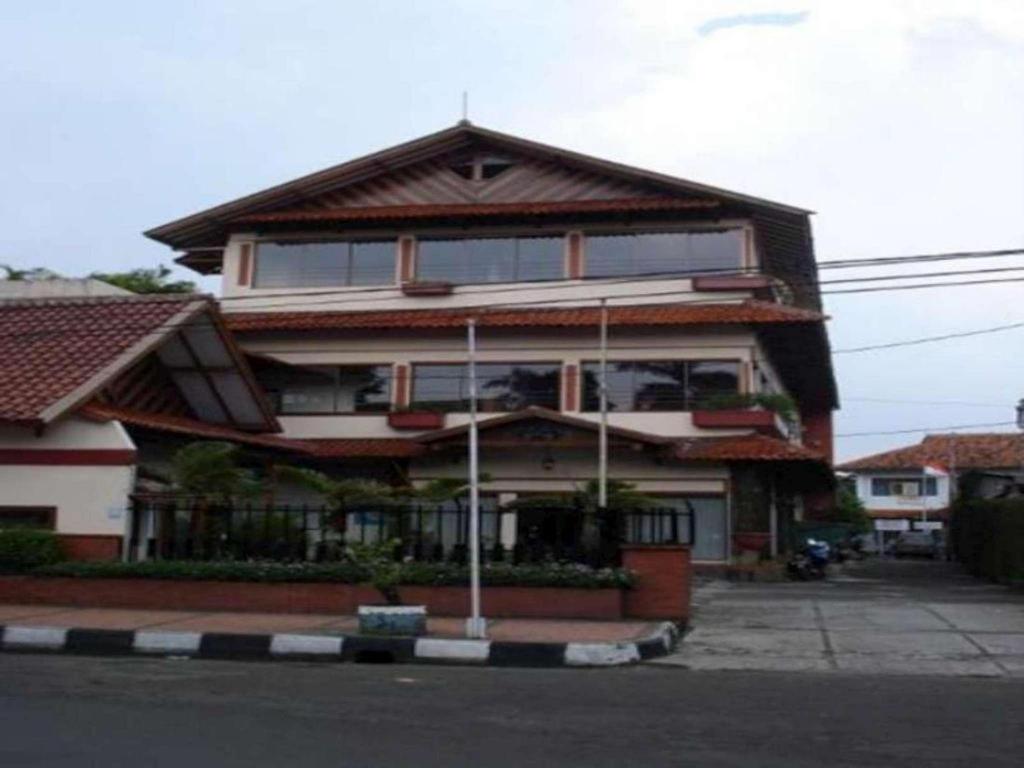 una casa grande con techo de gambrel en Kenangan Bandung Hotel en Bandung
