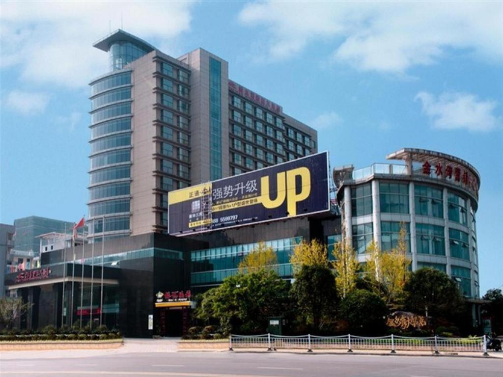 duży budynek z znakiem przed nim w obiekcie Guilin Jinshuiwan International Hotel w mieście Lingui