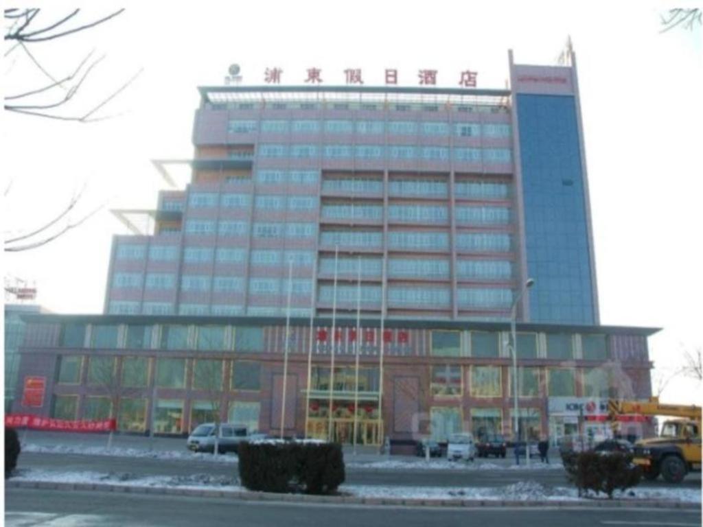a large office building with a lot of windows at Aksu Pudong Holiday Hotel in Aksu