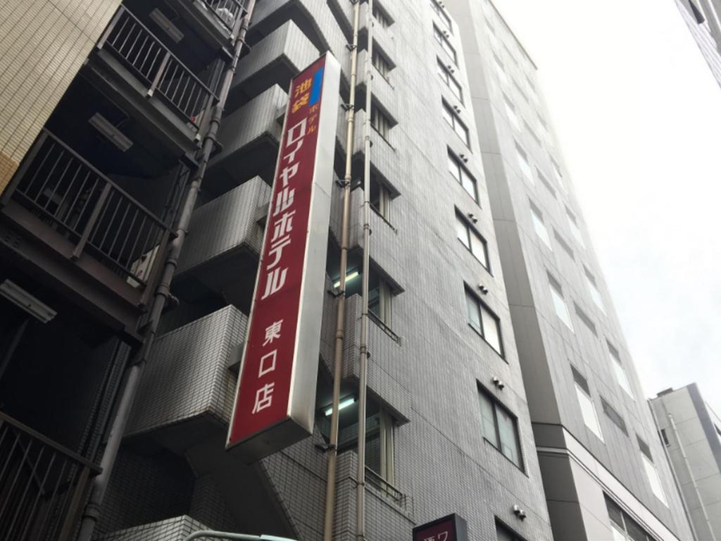 een rood bord aan de zijkant van een gebouw bij Ikebukuro Royal Hotel Higashiguchi in Tokyo