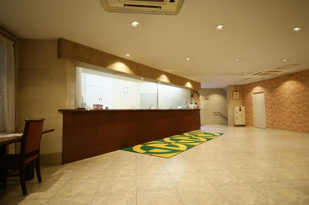 a large room with a kitchen and a rug on the floor at Kawasaki Green Plaza Hotel in Imai-kamichō