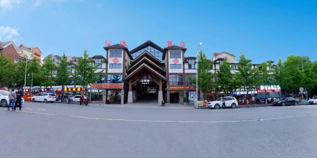 a large building with cars parked in a parking lot at Chongqing Xianyi Holiday Hotel in Wulong