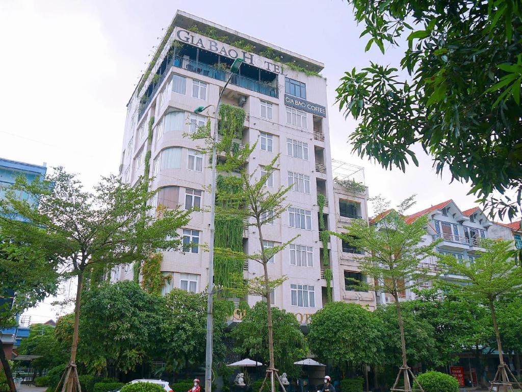Ein hohes weißes Gebäude mit einem Schild drauf. in der Unterkunft Gia Bao Hotel Bac Ninh in Ða Hội