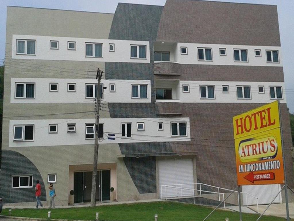 a large building with a hotel sign in front of it at Atrius Hotel in Rio Bonito