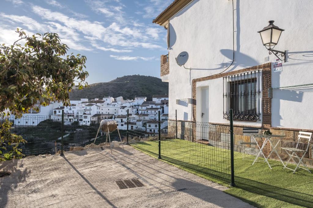 - une vue depuis le balcon d'une maison avec une vache dans la cour dans l'établissement La azomadilla, à Totalán