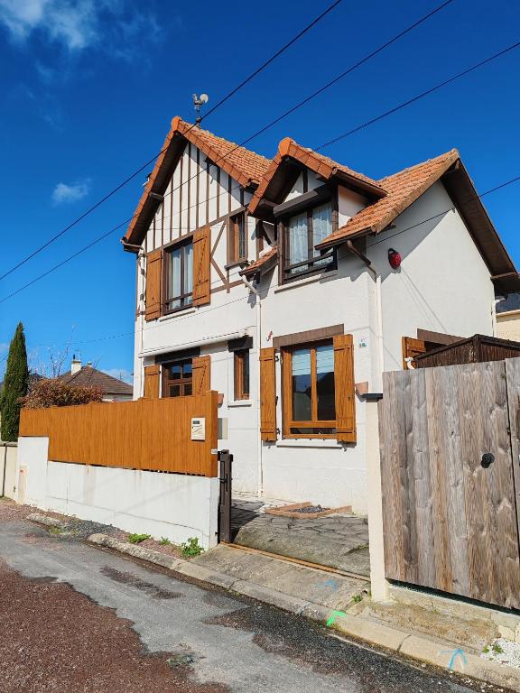 une maison blanche avec une clôture en bois dans l'établissement Villa Francette à 500m de la plage, à Ouistreham