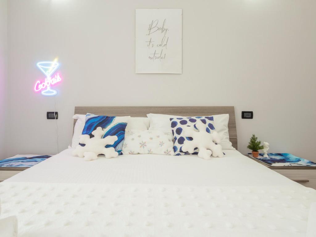 a bedroom with a white bed with blue and white pillows at Grazioso appartamento in Città Studi-20 min Duomo in Milan