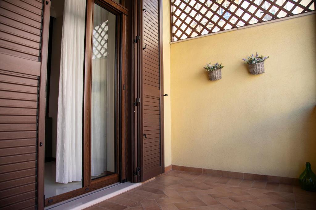 una porta aperta di una casa con due piante in vaso di Dimora cAmelia a Lucera