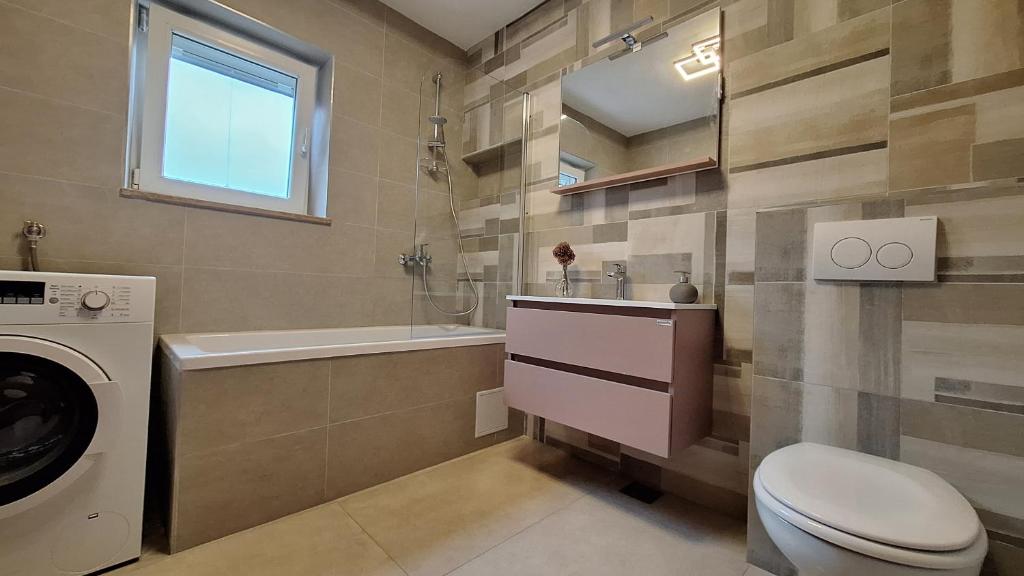 łazienka z toaletą, umywalką i pralką w obiekcie Istriamazing apartments w Puli