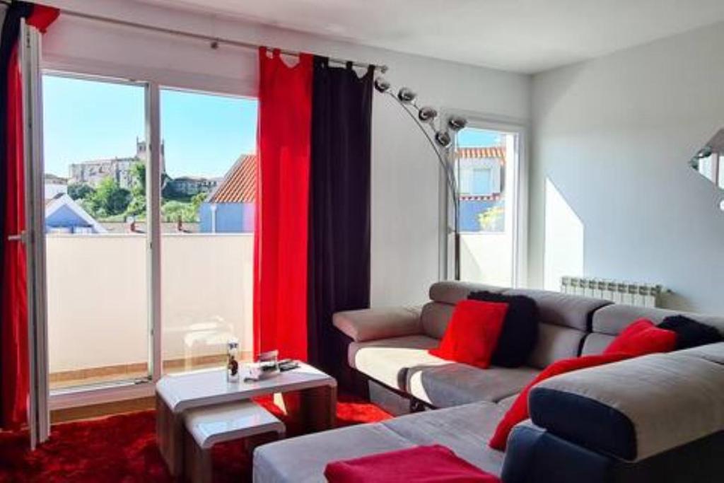 sala de estar con sofá y ventana grande en Grande Dúplex cerca del Mar, en San Vicente de la Barquera