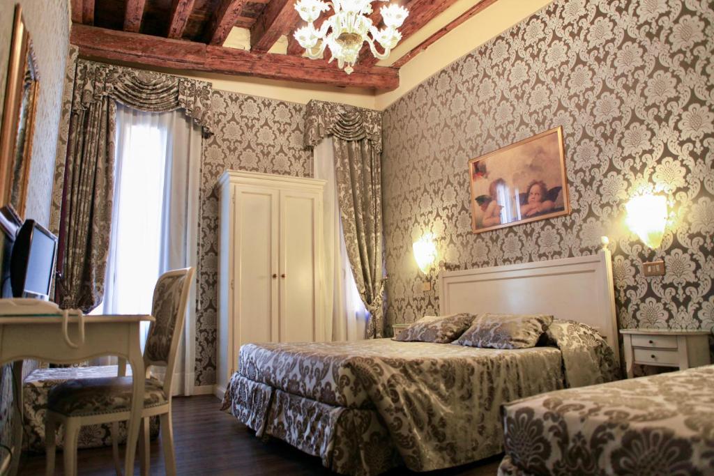 a hotel room with two beds and a desk at Hotel Bridge in Venice