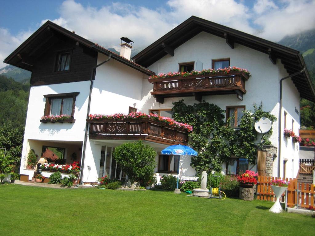 uma casa branca com caixas de flores e varandas em Gästehaus Sonnenheim em Thaur