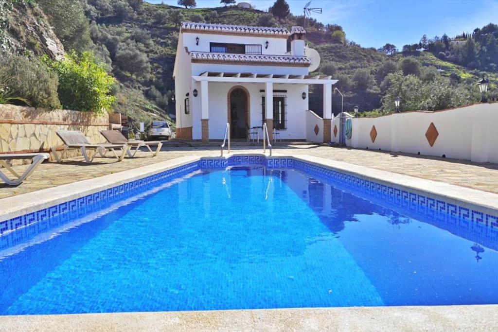 a villa with a swimming pool in front of a house at Casa Sueño Español in Torrox